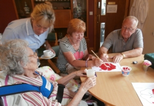 Rose and her family paint some poppies for the window display