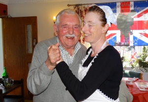 Wally and Elaine dance to the war time music.